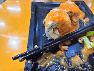 Photo of sushi with sauce on top. This food is a typical Japanese food. Sushi is made from rice with the addition of seafood, eggs and fresh vegetables