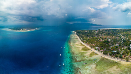 Aerial view of a tropical island, coral reef and stormy sky