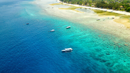 Tourist boats over a coral reef at low tide