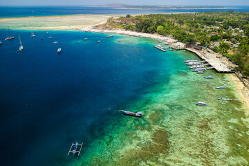 Obraz premium Boats surrounding a coral reef and small tropical island