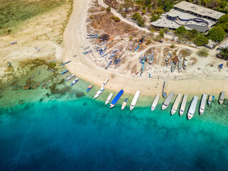 Lines of traditional wooden boats on the beach of a small tropical island surrounded by coral reef...