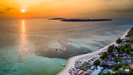 Aerial view of a beautiful tropical sunset and sandy beach resort (Gili Islands, Indonesia)