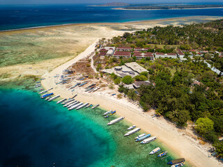 Lines of traditional wooden boats on the beach of a small tropical island surrounded by coral reef (Gili Air, Indonesia)