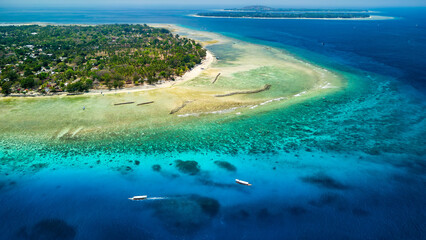 Aerial view of traditional outrigger type boats with snorkelers and swimmers over a tropical coral...