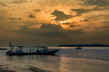 Traditional wooden boats on a tropical beach at sunset