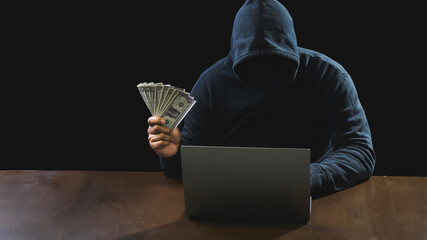 Portrait hacker spy man one person in black hoodie sitting on table looking computer laptop used login password attack security to data digital internet network system night dark background copy space - obrazy, fototapety, plakaty
