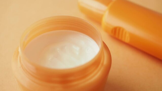 Close up of sunscreen cream ion orange color background 