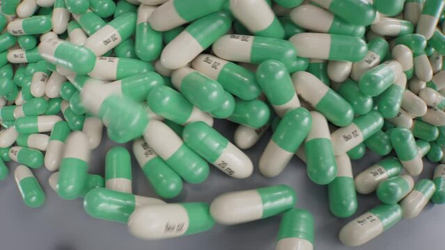Anxiety medication capsules rolling on the table, green white, dynamic shot, 3d animation, psychedelic.