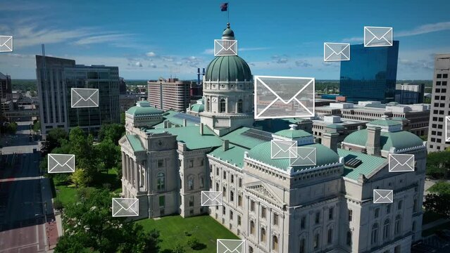 Indiana Statehouse with mail in ballot envelopes floating around capitol building in downtown Indiana. State government election and voting theme. Aerial.