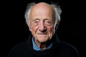 Portrait of an elderly man on a black background. Studio shot.