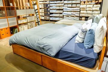 Double beds with glazed linens, duvet, sheets and pillows in furniture store