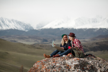 Two traveler girls with map sitting on rock in mountains - 766807836