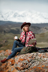 Portrait girl traveler with hat and mug on background of mountains - 766808221