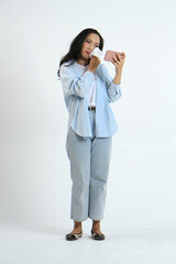 full lenght shoot of asian indonesian woman holding smartphone and tissue with sad expression on...