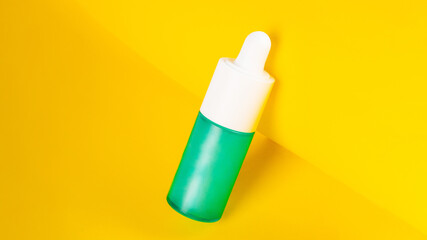 Blue glass cosmetic bottle, Skin care or sunscreen cosmetic on yellow background.