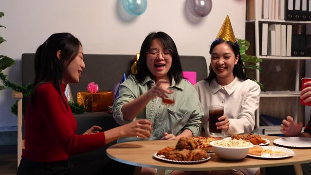 Group of happy Asian young people with friends celebrating during party, food, pizza, snacks with drinks and delicious food. Holiday concept, lifestyle.