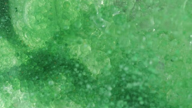 Abstraction, Macro View Under The Green Water Surface Into Which Something Is Poured, Forming Numerous Bubbles.