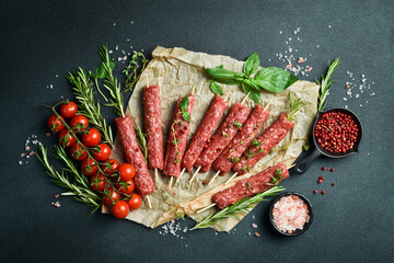 Raw Lyulya kebab with spices and herbs, ready for cooking. On a dark stone background. Top view....