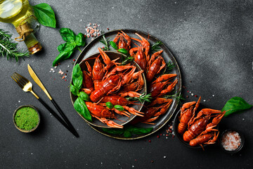 Crayfish. Red boiled crawfishes in a bowl with rosemary and spices. On a dark background. Free space for the recipe.