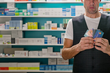 Closeup photo of young man paying for medicaments and drugs at pharmacy with credit card. Payment...