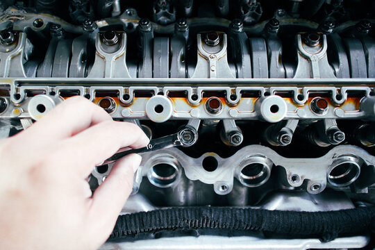 Car mechanic checking and adjusting valves of car engine, Car maintenance concept