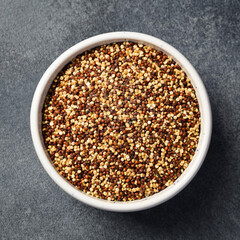 Close up of quinoa cereal in a bowl. On a dark concrete background.