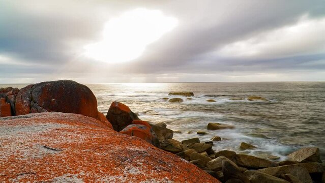 Sunrise at the Bay of Fires in Australia on top of rocks with red algae, timelapse slider