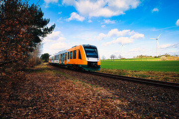 Regionalbahn mit grünem Feld , Wolken und Windkraft im Hintergrund - Train on the Railway - ...