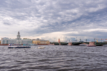 Am Fluss der Newa in St. Petersburg in Russland, im Hintergrund ist die Peter und Paul Kathedrale auf der Haseninsel zu sehen und viele Boote und Segelschiffe - obrazy, fototapety, plakaty