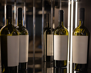 product photo of bottle with white label and glass with red white on hold in restaurant or in rack...