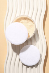 A bottle of powder, light shade, on a beige background.