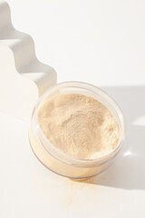 Face powder, light shade on a light background.