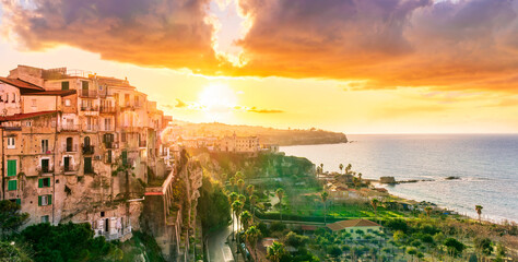 beautiful sunset landscape above sea coastline in Tropea, Italy. Antique buildings on a high rock...