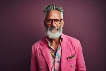 Portrait of a handsome senior man in a pink jacket and glasses.