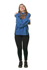 Studio portrait of a blonde Caucasian woman hugs, smiling carefree and happy.