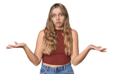 Studio portrait of a blonde Caucasian woman doubting and shrugging shoulders in questioning gesture.