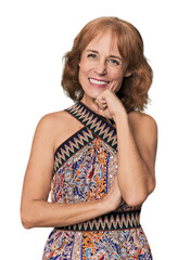 Redhead mid-aged Caucasian woman in studio smiling happy and confident, touching chin with hand.