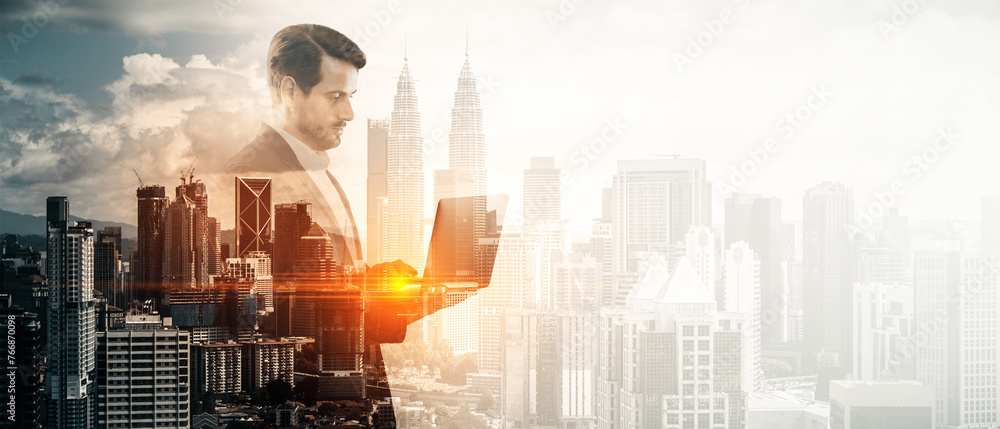 Poster abstract image of businessman using laptop on bright wide toned city background with mock up place. 