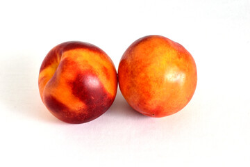 Two ripe nectarines on white.