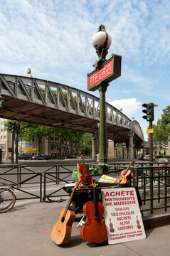 PARIS, FRANCE - MAY 08, 2011:  Paris metro sign at Jaures with with advertisement display of musical instruments
