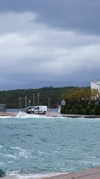 Dangerous parking lot near the beach. Powerful waves crashing the coast in Njivice, Croatia one day after Storm Ciar&aacute;n smashed into Krk Island. Disquiet blue sea surface, cars in danger.