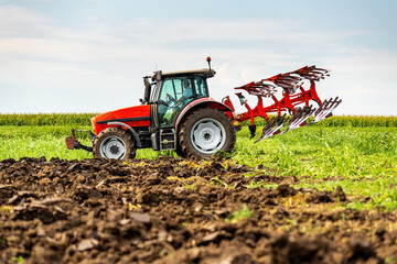 Agricultural tractor tilling fertile soil, readying the field for sowing