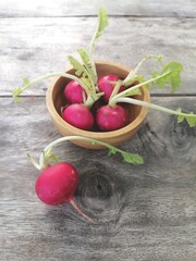 Fresh red radish vegetables on wooden background.