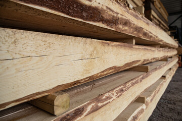 stacks of raw wood logs and lumber in warehouse