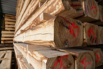 stacks of raw wood logs and lumber in warehouse