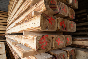 stacks of raw wood logs and lumber in warehouse