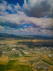 Obraz premium Aerial view of village houses, fields, mountain and plain. Landscape shooting in cloudy weather. 2023