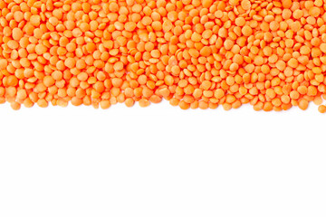 Uncooked red lentils border on white background. Copy space for text. Top view