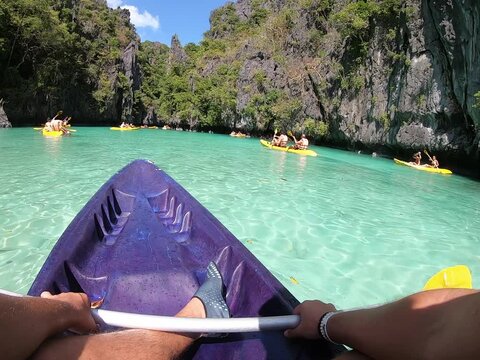 Individual paddling aboard a watercraft in a serene natural landscape Palawan Puerto Princesa Philippines