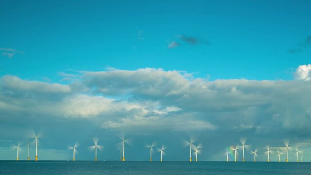 A timelapse of an offshore windfarm with a rainbow